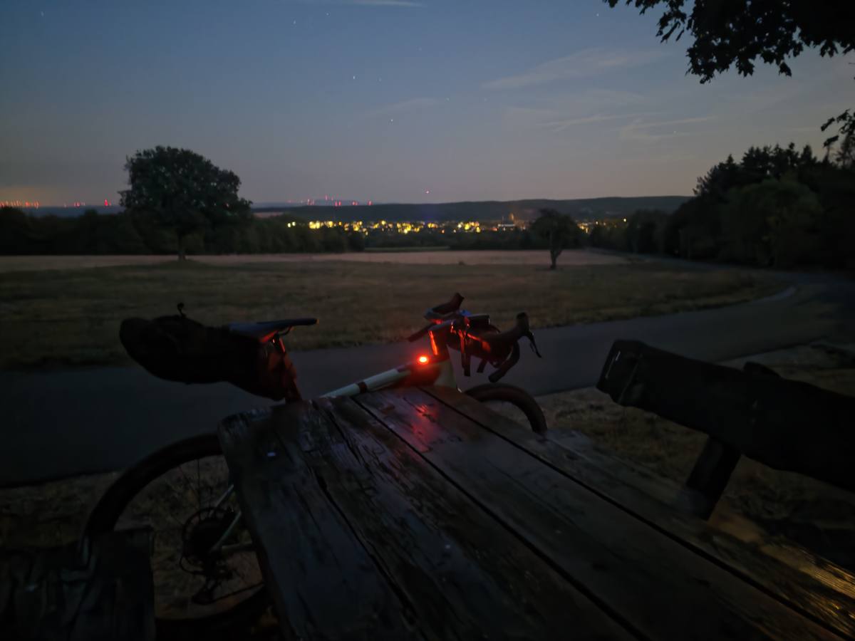 Nachtrast mit Aussicht: die Lichter der Dörfer im Tal, das Rücklicht glüht.