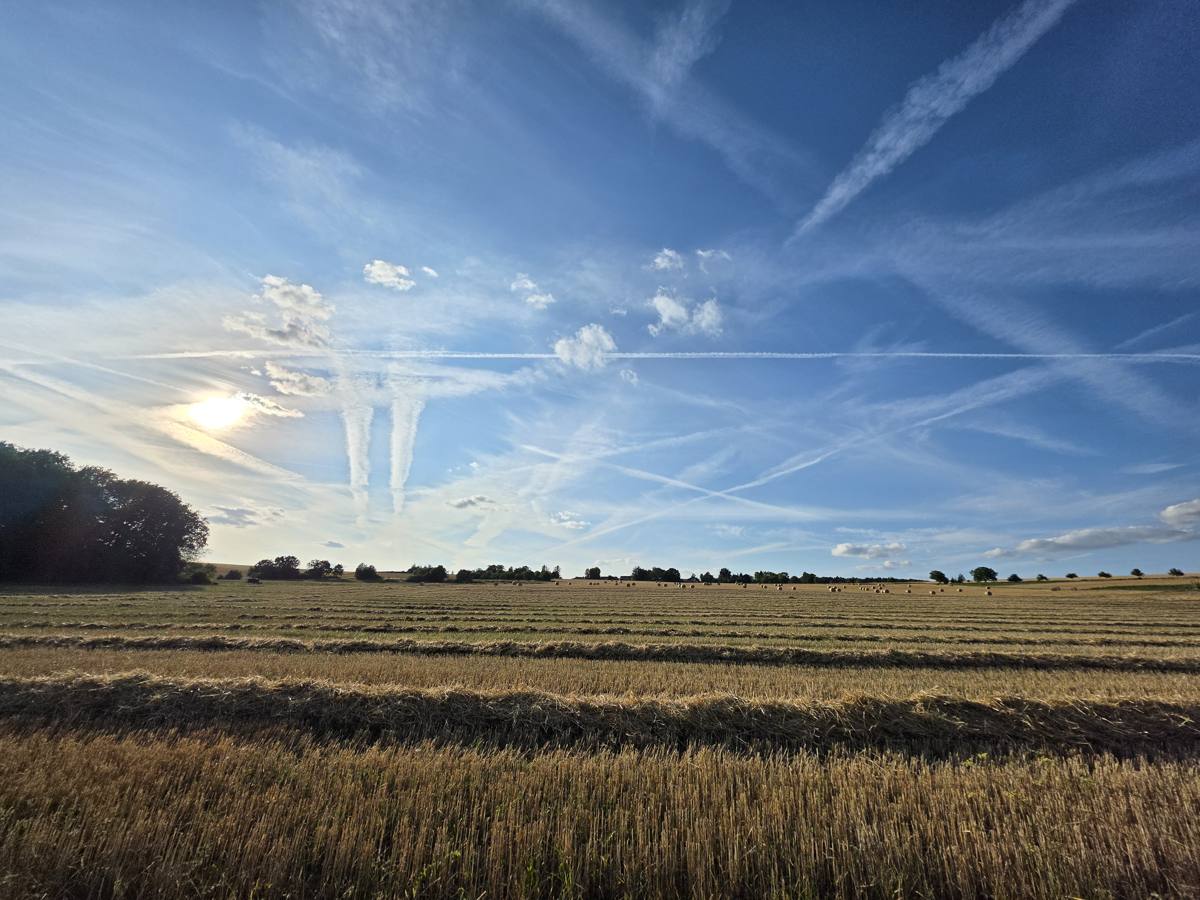Stoppelfelder, Heuballen, Kondensstreifen.