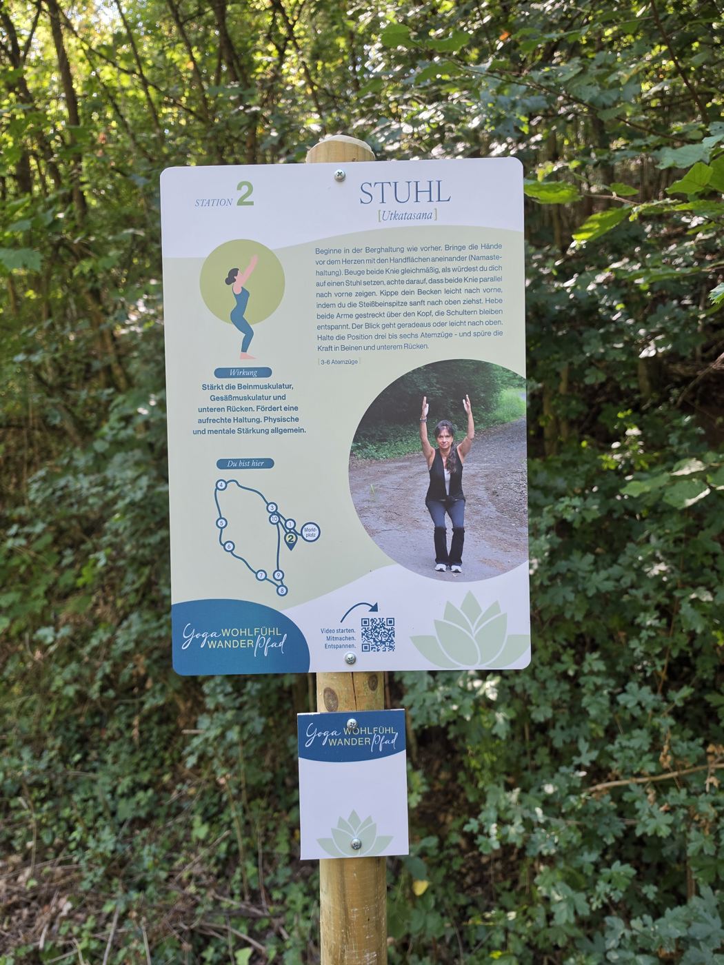 Schild Station 2 Stuhl des Yoga-Wohlfühl-Wanderpfads im Wald