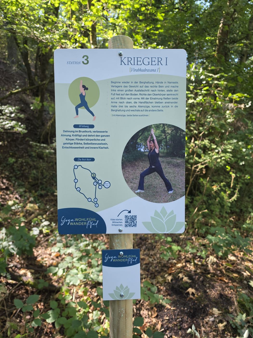 Schild Station 3 Krieger I des Yoga-Wohlfühl-Wanderpfads im Wald